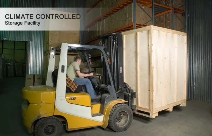 Forklift moving a wooden storage vault inside the climate controlled warehouse